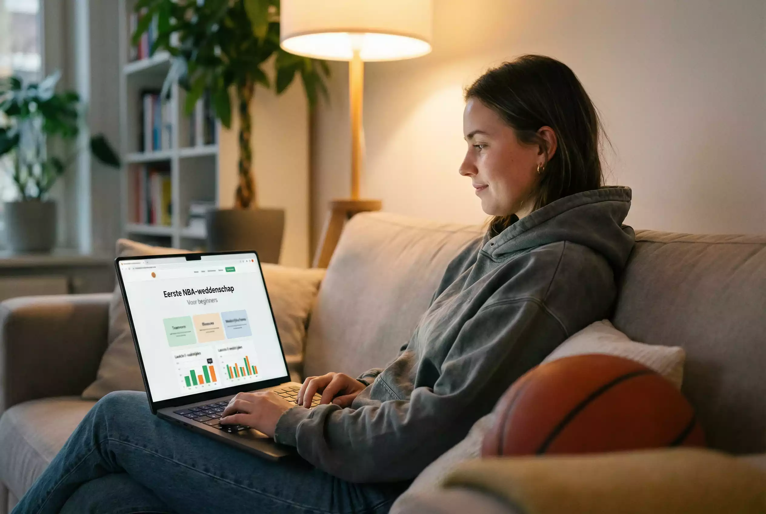 Persoon bekijkt NBA-statistieken op een laptop in een woonkamer